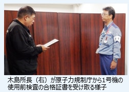 木島所長（右）が凱旋門 賞 オ ルフェーヴル力規制庁から1号機の使用前検査の合格証書を受け取る様子